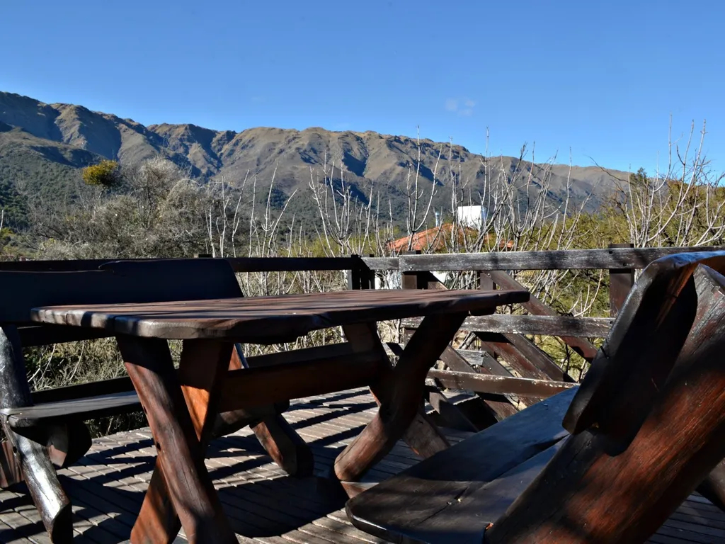 Deck de madera con mesa y vista a las sierras de los Comechingones, Cabañas de los Comechingones, Merlo